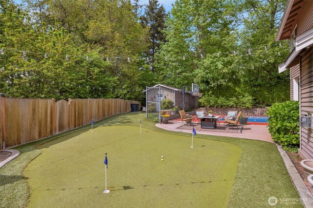 1401 241st St SE, Bothell, WA 98021 - fenced backyard featuring a putting area, a fire pit, a patio area, and an outdoor structure