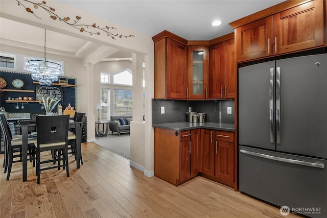 1401 241st St SE, Bothell, WA 98021 - kitchen featuring freestanding refrigerator, light wood-style flooring, a chandelier, glass insert cabinets, and dark countertops