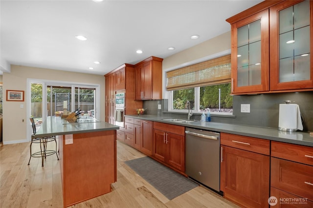 1401 241st St SE, Bothell, WA 98021 - kitchen featuring appliances with stainless steel finishes, a sink, light wood finished floors, a breakfast bar, and recessed lighting
