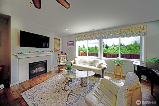 5042 Mariner St, Gig Harbor, WA 98332 - living area with wood finished floors, a tiled fireplace, ceiling fan, and baseboards