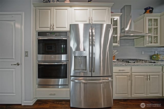 5042 Mariner St, Gig Harbor, WA 98332 - kitchen with appliances with stainless steel finishes, wall chimney exhaust hood, glass insert cabinets, and light stone counters