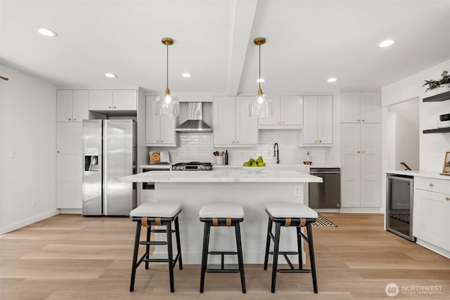 354 Summit Ave, Fircrest, WA 98466 - kitchen featuring appliances with stainless steel finishes, wall chimney range hood, a kitchen bar, tasteful backsplash, and white cabinets