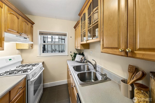 516 E Thomas St Unit 105, Seattle, WA 98102 - kitchen featuring white range with gas cooktop, under cabinet range hood, a sink, glass insert cabinets, and dark tile patterned flooring