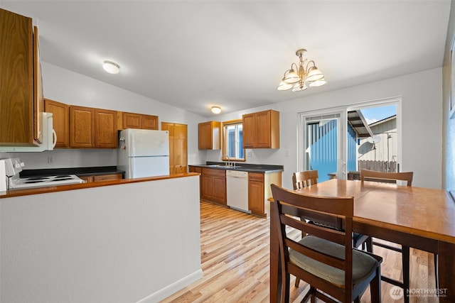 412 Algona Blvd S, Algona, WA 98001 - kitchen featuring white appliances, a chandelier, dark countertops, vaulted ceiling, and light wood-style floors