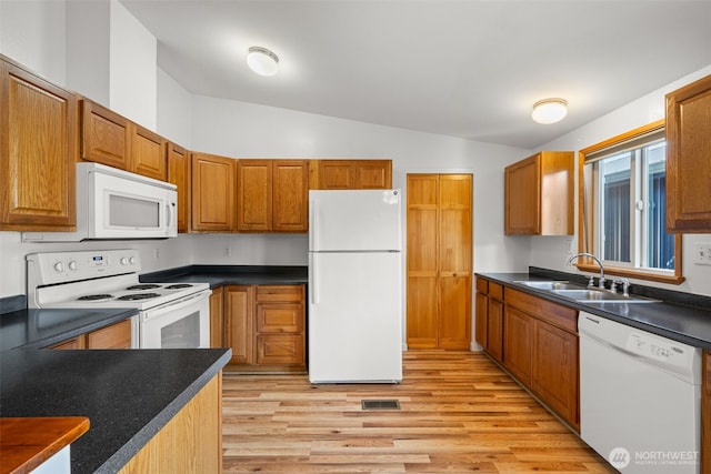 412 Algona Blvd S, Algona, WA 98001 - kitchen with white appliances, vaulted ceiling, light wood-type flooring, dark countertops, and brown cabinetry