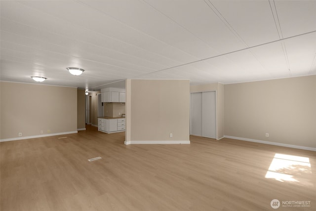 below grade area with light wood-style flooring and baseboards