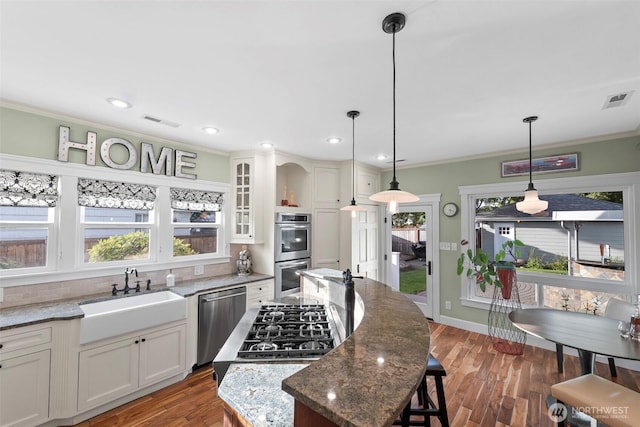 515 4th Ave SW, Puyallup, WA 98371 - kitchen with appliances with stainless steel finishes, a sink, crown molding, dark stone countertops, and a kitchen island