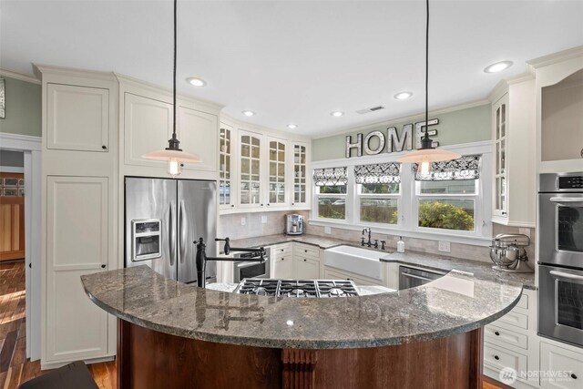 515 4th Ave SW, Puyallup, WA 98371 - kitchen with stainless steel appliances, a sink, tasteful backsplash, a kitchen island, and recessed lighting
