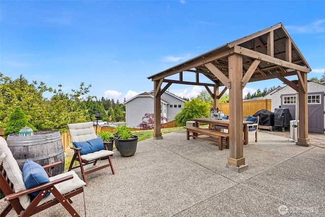 21032 Nordby Dr NW, Poulsbo, WA 98370 - view of patio / terrace with outdoor dining space, fence, a gazebo, a storage unit, and an outdoor structure