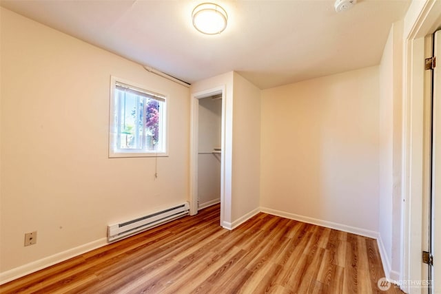 2630 58th Ave SW Unit 1-4, Seattle, WA 98116 - unfurnished bedroom with a baseboard heating unit, light wood finished floors, baseboards, and a closet