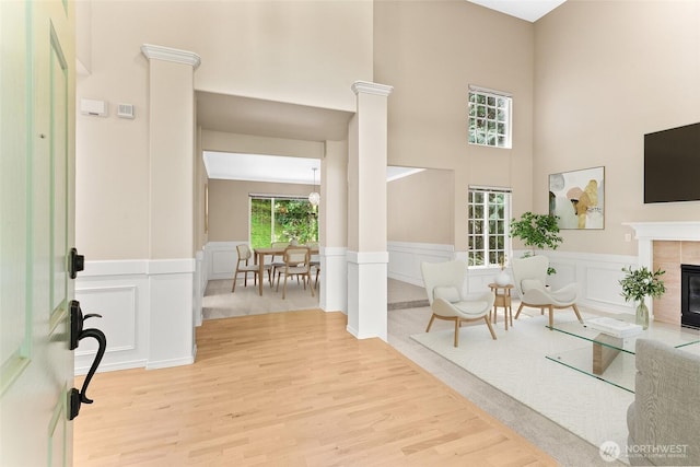 6336 286th Pl NE, Carnation, WA 98014 - foyer with light wood-style flooring, a tile fireplace, a wainscoted wall, a decorative wall, and a towering ceiling