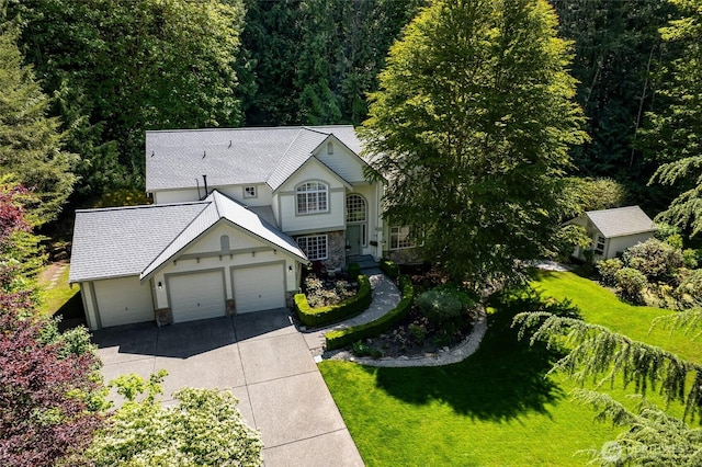 6336 286th Pl NE, Carnation, WA 98014 - view of front facade with stone siding, concrete driveway, a garage, a front lawn, and a shingled roof