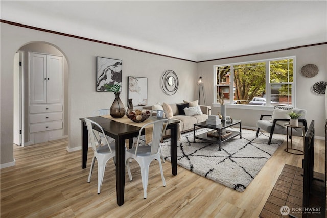 1602 NW 83rd St, Seattle, WA 98117 - dining area featuring arched walkways, light wood-style flooring, baseboards, and crown molding