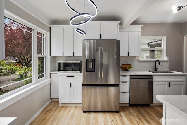 1602 NW 83rd St, Seattle, WA 98117 - kitchen featuring stainless steel appliances, a sink, tasteful backsplash, light countertops, and beam ceiling