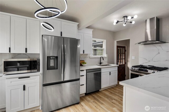 1602 NW 83rd St, Seattle, WA 98117 - kitchen featuring appliances with stainless steel finishes, wall chimney range hood, a sink, tasteful backsplash, and beamed ceiling