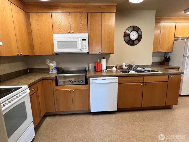 1415 84th St SE Unit 45, Everett, WA 98208 - kitchen featuring white appliances, dark countertops, a sink, and brown cabinetry