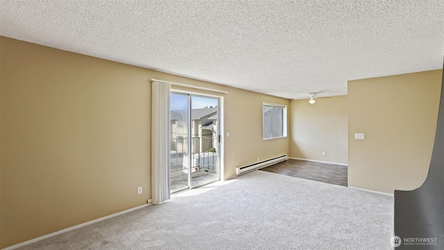 spare room with a baseboard heating unit, carpet floors, a textured ceiling, and baseboards