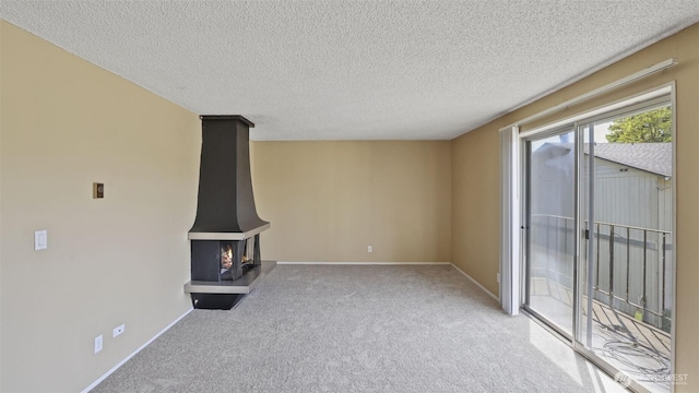 unfurnished living room with carpet, a textured ceiling, and baseboards
