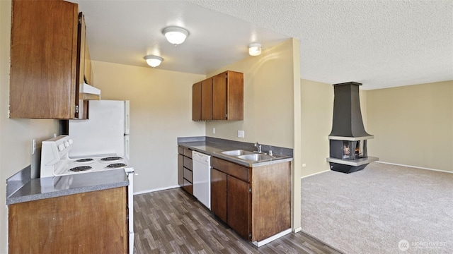 kitchen with a sink, white appliances, under cabinet range hood, baseboards, and dark wood-type flooring