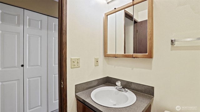 bathroom with vanity and a closet