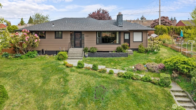 view of front of property featuring a vegetable garden, a front yard, a chimney, and roof with shingles