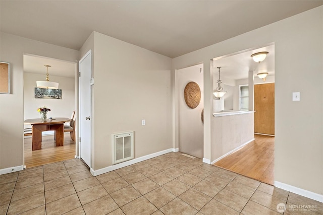 spare room with light tile patterned flooring and baseboards