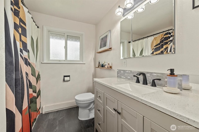 bathroom with baseboard heating, toilet, vanity, baseboards, and a shower with shower curtain