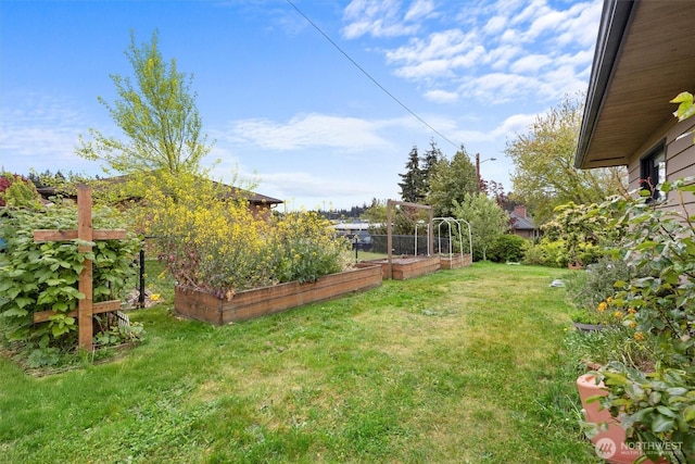 view of grassy yard featuring a garden