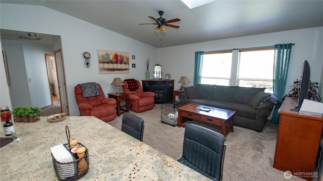 71 E N Bay Pl, Allyn, WA 98524 - carpeted living room with vaulted ceiling, ceiling fan, and a wood stove