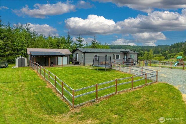 882 Independence Rd, Rochester, WA 98579 - single story home with an outbuilding, a detached garage, a shed, and a view of trees