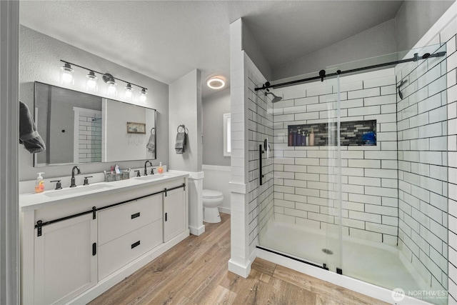882 Independence Rd, Rochester, WA 98579 - bathroom with a stall shower, toilet, wood finished floors, double vanity, and a textured ceiling
