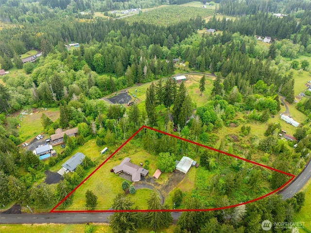 aerial overview of property's location with property boundaries highlighted and a forest
