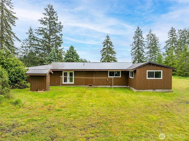 rear view of house with a lawn, metal roof, french doors, and crawl space