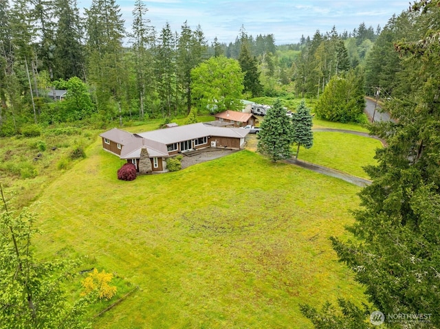 aerial view of property and surrounding area featuring a forest