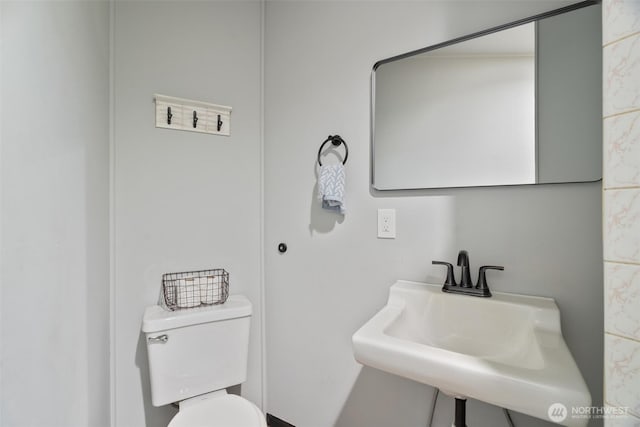 half bath featuring a sink and toilet