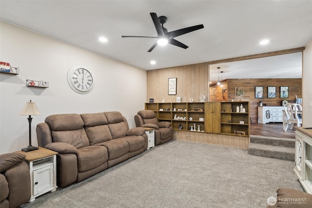 living area with wood walls, a ceiling fan, carpet flooring, and recessed lighting