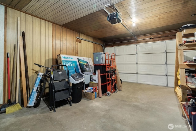 garage featuring a garage door opener and wooden walls