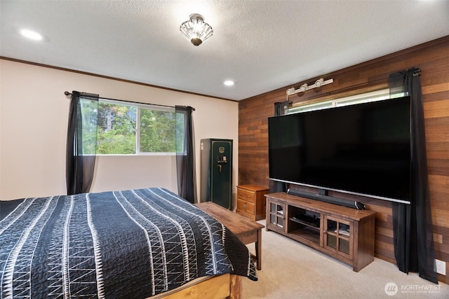 carpeted bedroom featuring wood walls, recessed lighting, and a textured ceiling