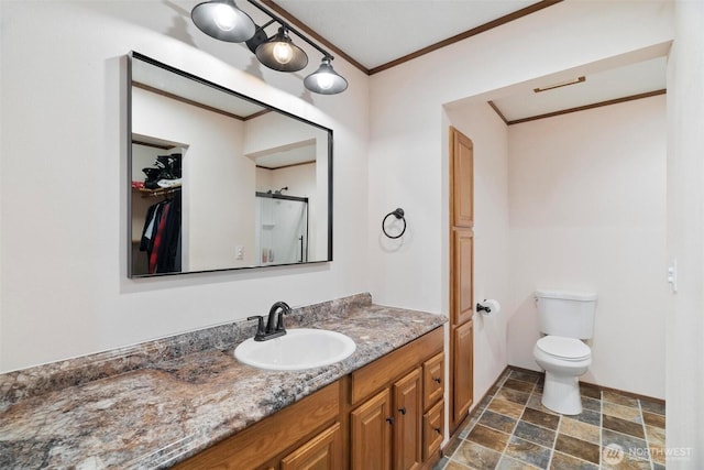 full bath featuring stone finish flooring, ornamental molding, vanity, toilet, and a shower
