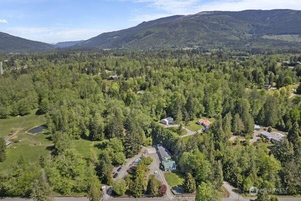 aerial view of property's location with a forest and a mountain backdrop