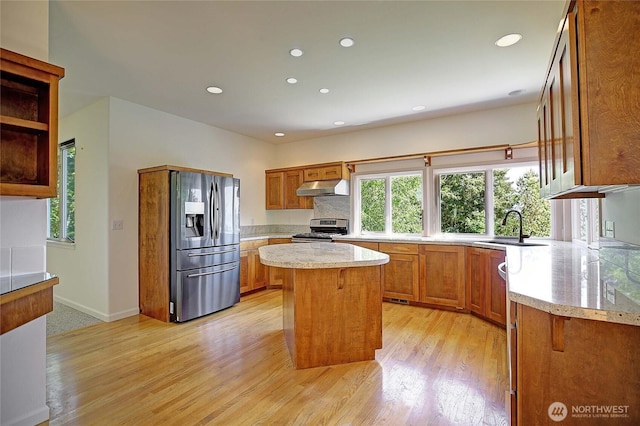 955 Michael Way, Camano Island, WA 98282 - kitchen with under cabinet range hood, stainless steel appliances, a sink, brown cabinets, and light wood-style floors