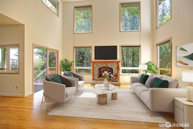 955 Michael Way, Camano Island, WA 98282 - living area with a high ceiling, wood finished floors, a warm lit fireplace, and baseboards