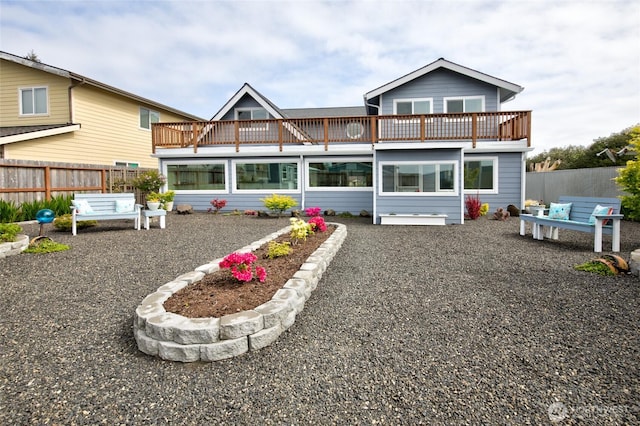 back of property with fence and a balcony