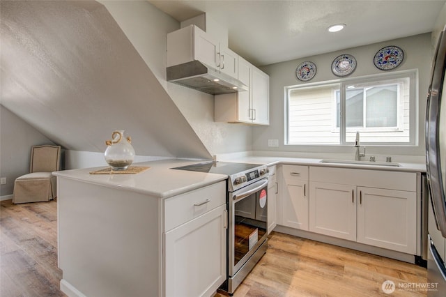 kitchen featuring appliances with stainless steel finishes, a sink, under cabinet range hood, white cabinets, and light wood finished floors