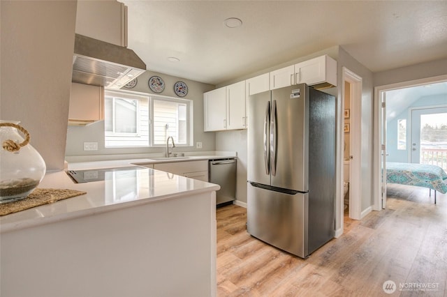 kitchen featuring appliances with stainless steel finishes, range hood, white cabinets, light wood-style flooring, and light countertops