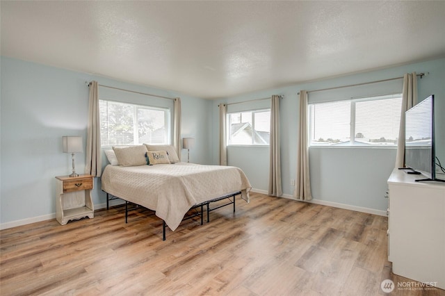bedroom with light wood-style flooring and baseboards