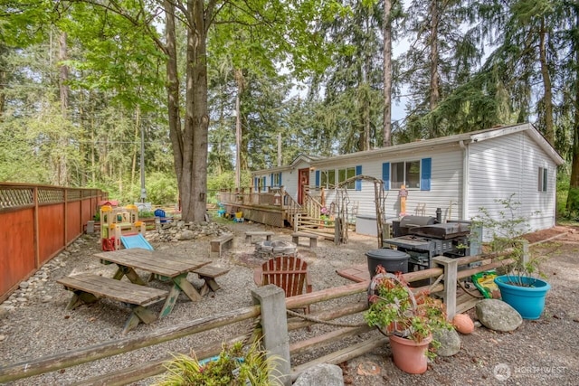 rear view of property featuring a deck and fence