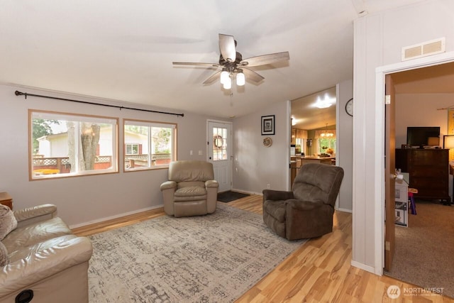 living room featuring light wood-type flooring, a ceiling fan, and baseboards