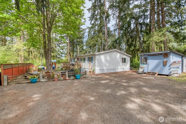 view of home's exterior featuring an outbuilding, view of scattered trees, and a storage unit