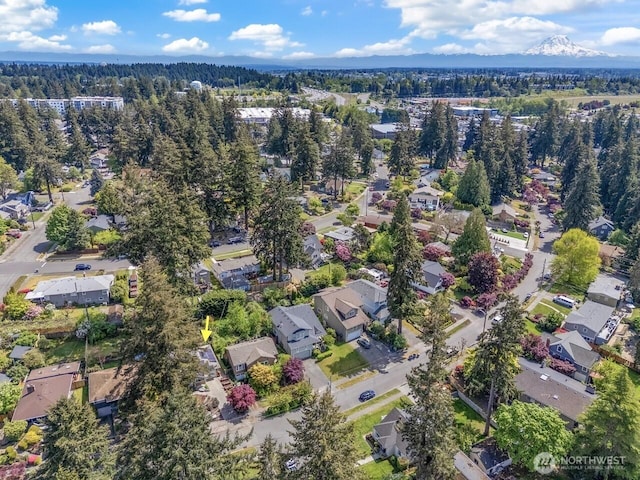 view of property location featuring nearby suburban area and a heavily wooded area